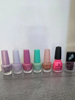 Nagellackspaket i pastell och neon - Säljer ett paket med sju nagellack i olika färger: lila shimmer, ljuslila matt, rosa, mintgrön, beige, neonrosa och mörklila. Märkena är Technic, China Glaze och Catrice. Flaskorna har klassisk rund form och lacket är i flytande formula. Vissa är provade en gång och vissa är helt oanvända.