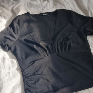Finare t-shirt  - Svart topp från bikbok. Aldrig använd men den är sydd vid i klyftan. Säljer pågrund av att jag aldrig använt den men en jätte fin topp som passar perfekt till sommaren!
