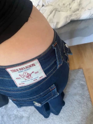 Mörkblå True Religion jeans - True religion joey jeans i storlek w23. Lite färg har farit bort från dom och slitna längst ner från när jag har trampat på dom då dom är lite långa, kan skicka mer bilder privat 🤗priset kan diskuteras vill ha bort dom 