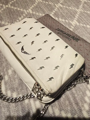 Zadig & Voltaire Rock Grain - Zadig & Voltaire Rock Grain , specialversion med silverfärgade blixtar.Båda kedjor kvar. Dustbag medföljer. Bra använt skick.