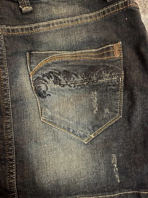 Jeans kjol - Tidigt 2000’s kjol med broderat tryck på bakfickorna