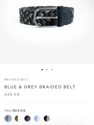 Flätat blått och grått bälte - Snyggt flätat bälte i blå och grå toner med silverfärgat spänne och detaljer i skinn. Perfekt accessoar för att lyfta din outfit med en modern touch. Längd 90 cm enligt märkning.
