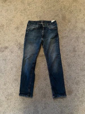 Jack& Jones slim glen - Snygga mörkblå jeans med raka ben och klassisk femficksdesign. Jeansen har subtila slitningar framtill och kontrastsömmar. Tillverkade i denim med en skön passform som funkar till allt. Storlek W29 L30. Hör av er vid fler funderingar✅