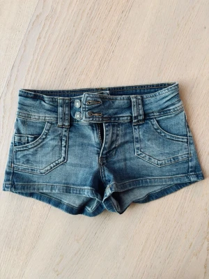 Snygga lowwaist jeansshorts - Snygga blå denimshorts från subdued med dubbla knappar och dragkedja framtill. Perfekta till sommaren för en trendig cool look. Pris kan diskuteras