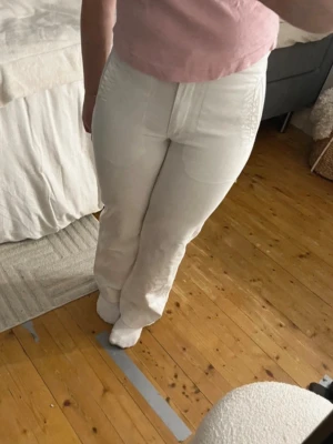 Vita jeans i mid waist  - Säljer ett par vita jeans med rak/bootcut passform och mid waist. Jeansen har klassisk femficksdesign och dragkedja fram. Perfekta till en avslappnad och trendig look. Materialet känns mjukt och bekvämt, passar till många olika stilar. Säljer även toppen. 