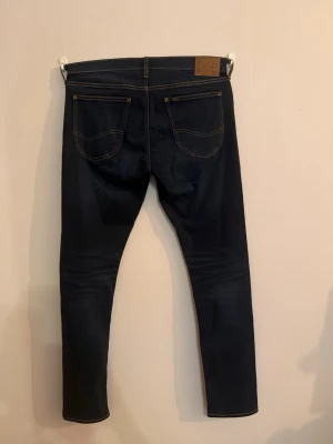 Lee Luke jeans – W33 L34  - Säljer ett par riktigt snygga Lee jeans i mörkblå tvätt. Modellen är Luke (slim fit), sitter bra och är sköna med lite stretch.  Jeansen är knappt använda och i mycket fint skick – inga slitningar eller fläckar. 
