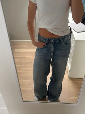 Blåa baggy jeans - Säljer ett par ljusblå baggy jeans. Jeansen har klassisk femficksmodell och är tillverkade i denim. Perfekta för en avslappnad och trendig look. Aldrig använda med lappen kvar!