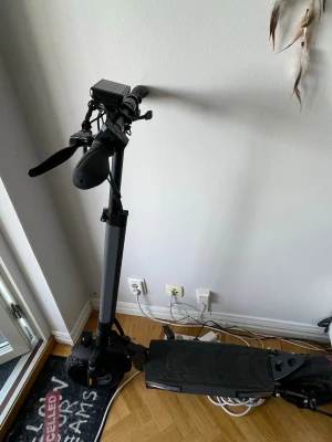 Iscooter W9 1000W använd 600km - Svart elsparkcykel och kör i 25km/h kan låsas upp till 45km/h men kommer olåst 25! och en med digital display på styret. Displayen visar bland annat hastighet, batterinivå och körläge. Sparkcykeln har belysning i fotplattan med både vita och orangea ljus. På bilderna syns även tillbehör och manual. Den kommer full laddad och finns även möjligheter att testa innan man bestämmer sig styret går att sänka och höja så den passar alla olika åldrar/längder. Batteri kapaciteten är 35-45km per laddning.