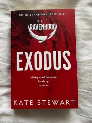 Exodus av Kate Stewart - Säljer boken 'Exodus' av Kate Stewart, del av The Ravenhood-serien. Omslaget är rött med vita detaljer och har en stilren design med fjädermotiv. Perfekt för dig som gillar internationella bestsellers och romantisk spänning.