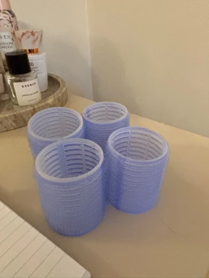 Ljuslila hårspolar i plast - Fyra stycken ljuslila hårspolar i plast med kardborre, perfekta för att skapa volym och lockar i håret. Cylindrisk form och enkel att använda för styling. Passar alla hårtyper och är smidiga att ta med i väskan.