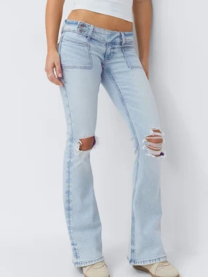 lågmidjade ljusblåa bootcut jeans med slitningar - Säljer ett par ljusblå bootcut jeans med slitna detaljer över knäna och råa kanter. Jeansen har hög midja, klassiska fickor fram och bak samt en avslappnad passform. Perfekta för en trendig och avslappnad look. säljer dessa billigare då de är lite smutsiga längst ner men syns knappt, fråga gärna om fler bilder!