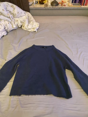 Mörkblå stickad tröja  - Mysig mörkblå stickad tröja från Gina Tricot med rund halsringning och långa ärmar. Tröjan har en enkel, rak passform och är perfekt för lager på lager under kyliga dagar. Passar till både jeans och kjol.