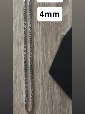 Silverpläterat kedjehalsband 58cm - Snyggt silverpläterat 4mm kedja. Kedjan har ett unikt, geometriskt mönster som ger ett modernt och stilrent intryck. Perfekt accessoar för att lyfta din outfit med en cool detalj.