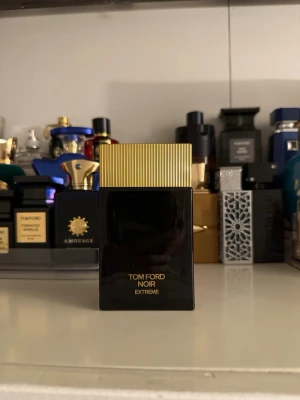 Tom Ford Noir Extreme parfym - Lyxig parfym från Tom Ford i modellen Noir Extreme. Flaskan är elegant svart med guldfärgat lock och har en stilren, rektangulär form. Perfekt för dig som gillar exklusiva dofter och snygg design på parfymhyllan.