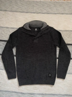 Grå/Svart stickad tröja  - Stickad tröja från petrol industriers i en grå ish färg. Krage med både knappar och gömd dragkedja. Skick 10/10, inga noppror ens