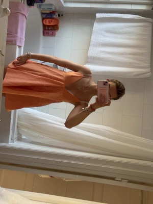 Orange kort klänning med smala axelband - Söt orange kort klänning med smala axelband och lätt v-ringning. Klänningen har en luftig passform och är perfekt för varma dagar. Klänning är från förra årets Zara kollektion ich säljs inte längre. Den är knappast andvänd! Pris kan diskuteras vid snabb affär!❤️