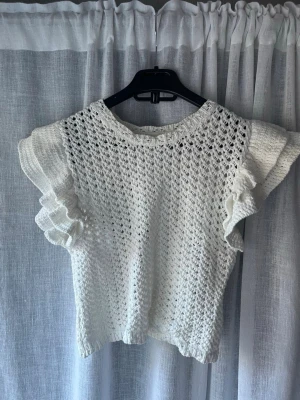 Vit virkad topp med volangärmar - Supersöt vit virkad topp med volangdetaljer på ärmarna, knappt använd😌Står ingen storlek men passar xs/s