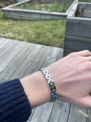 Silverfärgat armband från BOSS - Snyggt armband i silverfärgad metall från BOSS med stilren länkdesign och ingraverad logga. Nypris: 1500, kan justera armbandet till handled genom att ta bort länkar.
