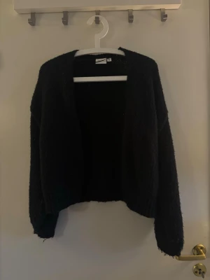 Svart fluffig kofta  - Mysig svart kofta med öppen front och avslappnad passform. Koftan är fluffig och har långa ärmar samt ribbade muddar vid ärmslut och nederkant. Perfekt att slänga på sig för en chill look.Hör av dig om du har några frågor! 💗🫶🏼