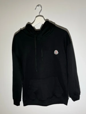 Moncler Hoodie - Super snygg Moncler hoodie med en moncler logga på vänstra bröstet. Hoodien är i storlek L men passar en grabb som är 175-85
