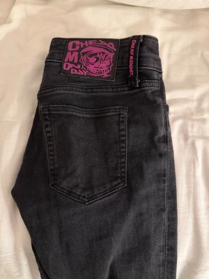 Bootcut jeans från Cheap Monday - Snygga svarta bootcut jeans från Cheap Monday med låg midja och skinny passform. Jeansen har en klassisk femficksdesign och ett coolt lila Cheap Monday-märke bak. Perfekta för dig som gillar en retro och edgy stil.