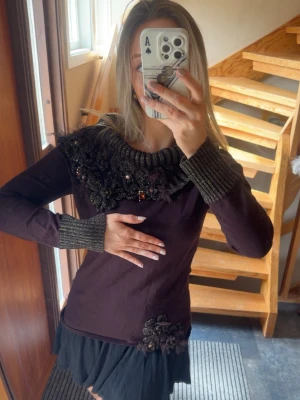 Maroon färgad tröja med dekorativ krage - Unik maroon tröja med lång ärm och bred ribbstickad krage i svart med dekorativa pärlor och blommor. Märket är ’Bellissima’ i storlek L men sitter mer som en Medium🙌🏻