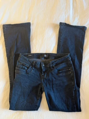 Mörkblå bootcut jeans - Superfina low waist jeans med bootcut från Ltb med broderier på bakfickorna, säljer då dom inte kommer till användning.