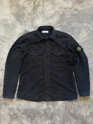Stone Island overshirt - Svart Stone Island overshirt i storlek XL (passar XL/L). Använd en del men är fortfarande i bra skick. Skriv vid frågor!