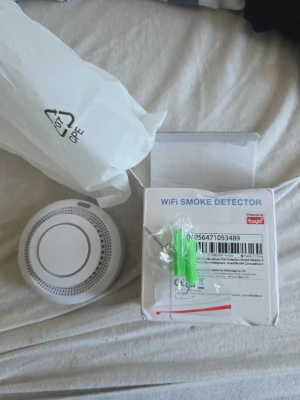 WiFi brandvarnare Tuya - Smart WiFi brandvarnare från Tuya i vit plast. Rund och kompakt design med ventilationshål runt kanten. Levereras med monteringskit och originalkartong. Perfekt för att koppla till ditt smarta hem och få notiser direkt i mobilen. Finns 3 stycken 1 styck 200kr