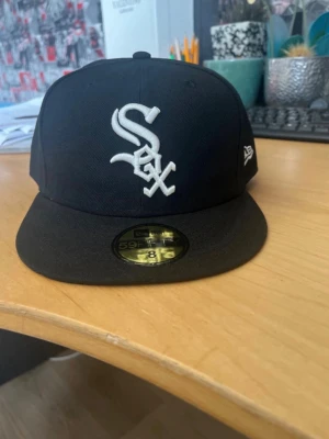 Svart New Era White Sox keps - Säljer en svart New Era 59FIFTY keps med Chicago White Sox-logga broderad i vitt framtill. Klassisk flat peak och broderad New Era-logga på sidan. Köpte från Vinted men va för stor skriv om ni vill veta mer eller få bilder på den