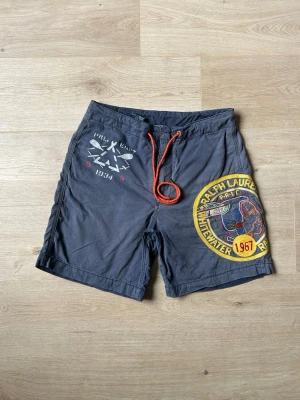 Blåa Rare Vintage Ralph Lauren Badshorts Storlek W30 - Mycket fina vintage shorts i blå färg. | Jeansen är i mycket bra skick och sparsamt använda. |  Äkta som allt annat jag säljer! ✅ |  Storlek: W30 | Skick: Mycket Bra Skick - Har tyvärr 2 små fläckar (SE SISTA 2 BILDER) | Färg: Blå | Märke: Ralph Lauren | Modell: Badshorts |   Hör gärna av dig vid frågor så svarar jag så fort jag kan! 😁 |  (SKU - 160)