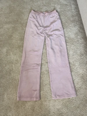 Ljuslila mjukisbyxor med raka ben - Säljer ett par ljuslila mjukisbyxor med raka ben och resår i midjan. Byxorna är i mjukt och skönt material, perfekta för en avslappnad stil. Passar dig som gillar bekväma och stilrena plagg.