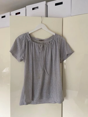 Vit topp med små svarta blommor - Luftig topp med knyte