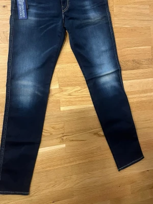 Helt nya Mörkblå Replay Hyperflex jeans - Snygga mörkblå jeans från Replay Hyperflex med slim fit och stretchigt material. Jeansen har klassisk femficksdesign, ljusa slitningar framtill och bakfickor med dekorativa sömmar. Perfekta för en trendig och bekväm look. W29 L32 frågor om priset tas via privat chatt 