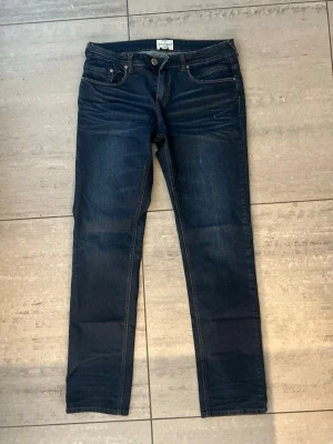 Mörkblå slim fit jeans från besserwisser! - Snygga mörkblå slim fit jeans med diskreta slitningar. Jeansen har normal midja och raka ben, Tillverkade i stretchigt denim. Står storlek w:34 L:34 i dom men tror dem kan vara aningen mindre än så! 