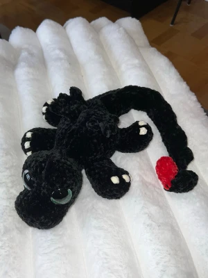 Virkad tabdlöse🖤 - Detta är en super söt svart drake med vita och röda detaljer, virkat med mjukt garn från Rusta som heter Klara🖤🖤🤍❤️ Den har hårda gröna ögon som inte går att ta av, sitter som bergen🖤🥰😆✨ Den är cirka 54 cm lång när man sträcker ut svansen✨