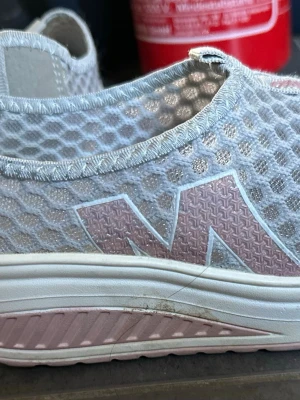 Ljusgrå mesh-sneakers med rosa detaljer - .Säljer ett par lätta och bekväma skor i storlek 35. Begagnade i jättebra skick, endast använda några veckor. Perfekta som vardagsskor eller promenadskor.