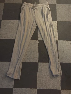 Beiga mjuka loungebyxor - Superbekväma loungebyxor i beige färg med dragsko i midjan och raka ben. Perfekta för att chilla hemma eller mysa runt i. Tillverkade i ett mjukt och lätt material som känns skönt mot huden.