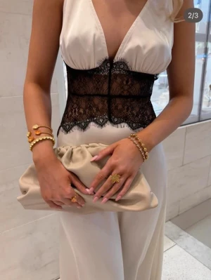 Svart spetsklänning från Golden Days Paris - Elegant långklänning från GD Paris i svart med djup v-ringning och bred spetsdetalj över midjan. Klänningen har en slät, flowy siluett som ger en lyxig känsla. Lagt in bilder på den fast i vitt så man ser detaljerna mer!! ❤️aldrig använd och köpt för 1100 men pris kan diskuteras❣️storlek M/L 