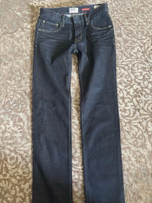 Mörkblå jeans från Crocker 312 Regular - Snygga mörkblå jeans från Crocker, modell 312 Regular. Klassisk femficksdesign med raka ben och kontrastsömmar. Tillverkade i ett bekvämt denimtyg som passar perfekt till din vardagsstil.