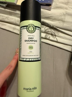 Maria Nila torrschampo 250 ml - Fräscht torrschampo från Maria Nila i en ljusgrön flaska med svart lock. Produkten är 100% vegansk och ger lätt stadga till håret. Perfekt för att snabbt fräscha upp håret mellan tvättarna. Helt oanvänd.