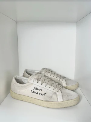 Saint Laurent Sneakers Vita  - Väldigt snygga och eftertraktade sneakers från Saint Laurent, perfekta sommarskorna! Bra skick, 8/10. Storlek 42. Endast skor. Kontakta mig för fler frågor och funderingar!