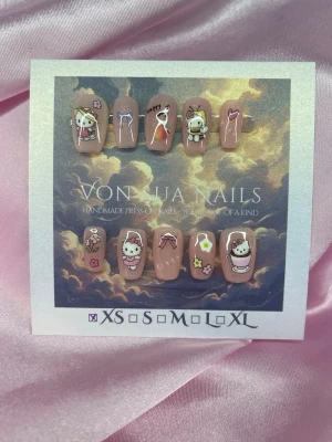 Kitty (XS);Short Ballerina - Handgjorda press-on naglar i nude med gulliga HK figurer, rosetter och små dekorationer i rosa, vitt och gult. Motiven inkluderar tecknade djur och söta detaljer. Perfekt för dig som vill ha unika och lekfulla naglar. Storlek XS: 14 mm, 11 mm, 11,5 mm, 10 mm, 8 mm .