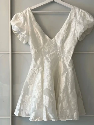 Vit studentklänning från Showpo - Supersöt populär vit kort studentklänning från Showpo med puffärmar och v-ringning. Helt ny. 