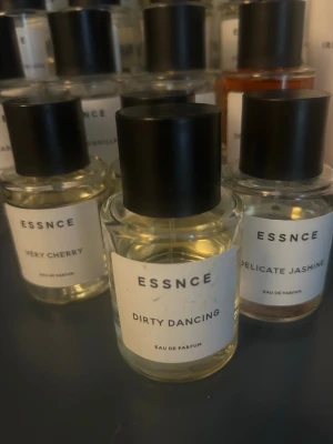 ESSNCE Dirty Dancing parfym - Parfymflaska från ESSNCE med doften Dirty Dancing. Flaskan är genomskinlig med svart lock och vit etikett. Modern och stilren design, perfekt för dig som gillar unika dofter. Materialet är glas och plast.