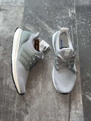 Adidas Ultra Boost - Helt nya oanvända adidas ultra boost skor med prislapp på med färgen grå och storlek 41, jätte sköna att gå med och jätte fina skor 