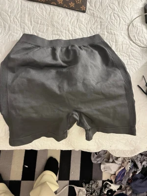 Mörkgrå seamless träningsshorts - Mörkgrå seamless shorts med ribbade detaljer längs sidorna och scrunch-effekt bak. Shortsen har bred resår i midjan för extra komfort och sitter tight. Perfekta för gymmet eller andra träningspass.