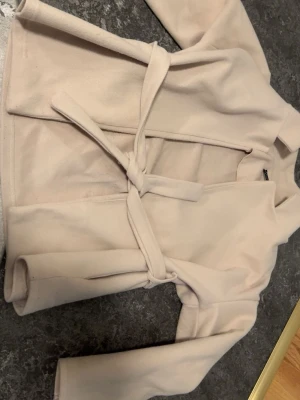 Beige kappa  - Beige kappa från missäy. Enkel att matcha med olika outfits.