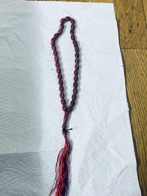 Rött misabaha med tofs - Snyggt misabaha med mörkröda ovala pärlor och en dekorativ röd tofs längst ner. Misabaha har en klassisk design och pärlorna har en glansig finish. 