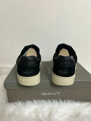 GANT sneakers - strl 45 nästan som nya - Säljer ett par svarta sneakers från GANT i storlek 45. Använda väldigt lite, så skicket är nästan som nytt. Inga större slitningar, fortfarande fräscha både utanpå och inuti. Orginalkartong följer med. Nypris på den är 1799. Skriv för mer bilder!